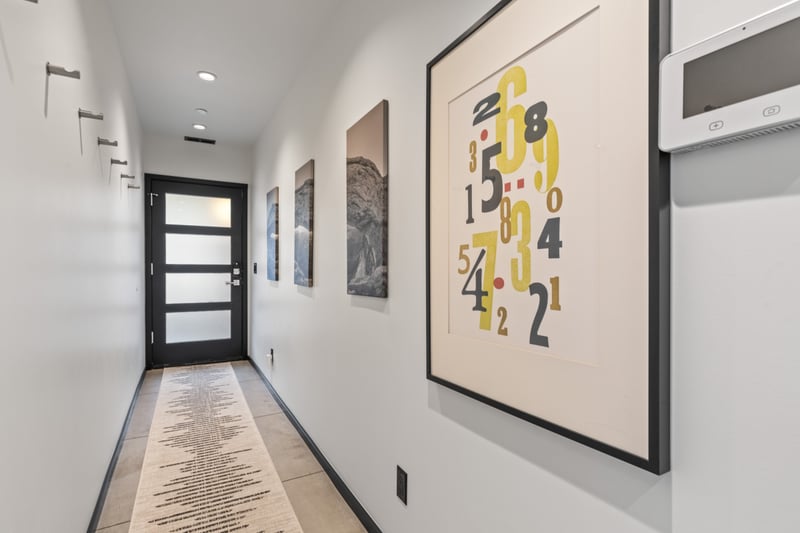 Art-lined hallway connects key areas with clean lines and plenty of light. PEA-1114