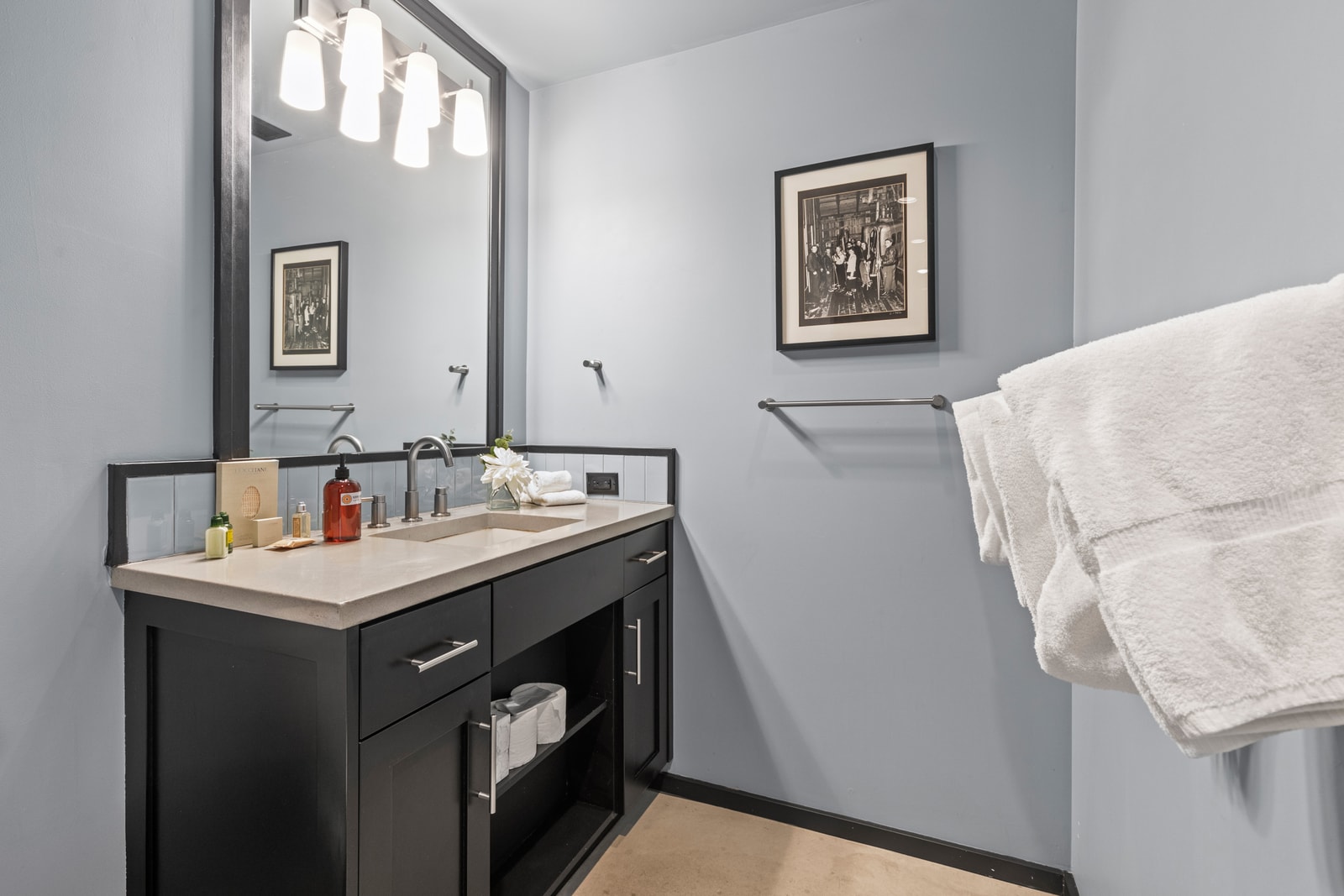 Granite vanity, bold blue tones, and full amenities complete this well-stocked bathroom.