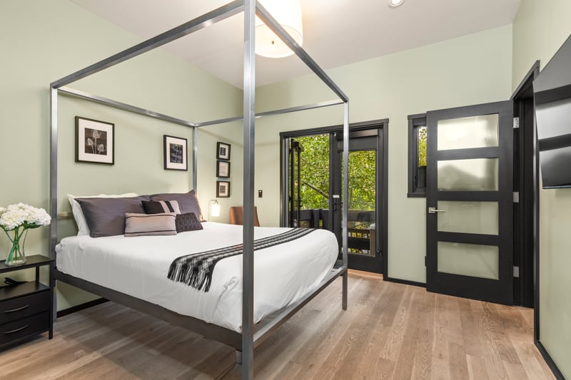 Second bedroom includes a Queen bed, four-poster frame, and access to the outdoor deck. PEA-1114