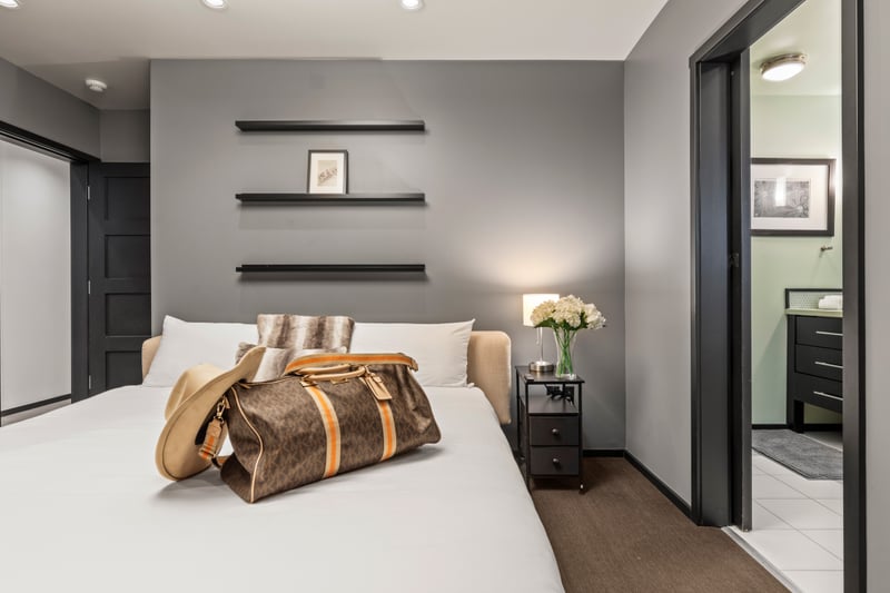 Crisp white linens and dark wood accents create a calming retreat in the primary bedroom. PEA-1114
