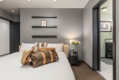 Crisp white linens and dark wood accents create a calming retreat in the primary bedroom. PEA-1114
