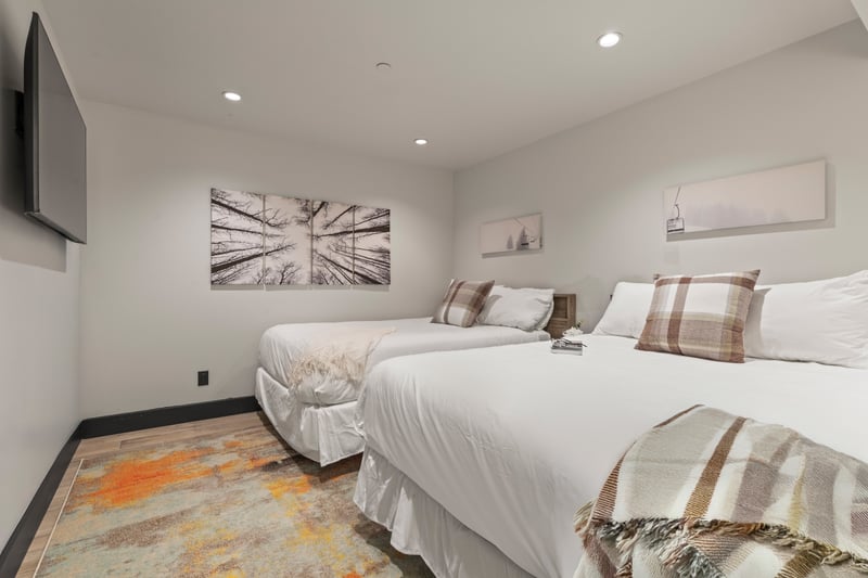 Another angle of the double-full room shows generous size and soft neutral décor.