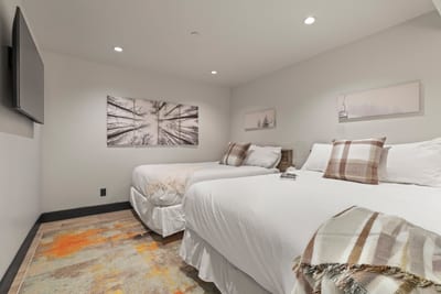 Another angle of the double-full room shows generous size and soft neutral décor.