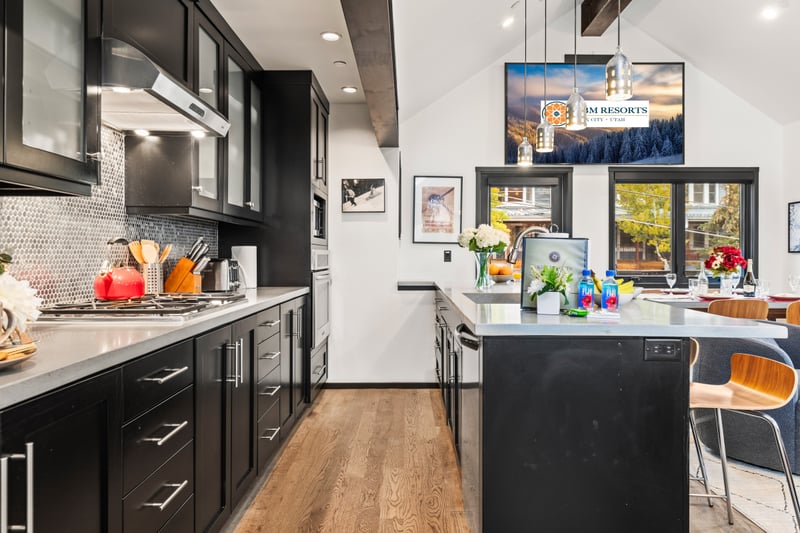 Wood floors and soft lighting give the kitchen a clean, modern feel for any meal or gathering. PEA-1114