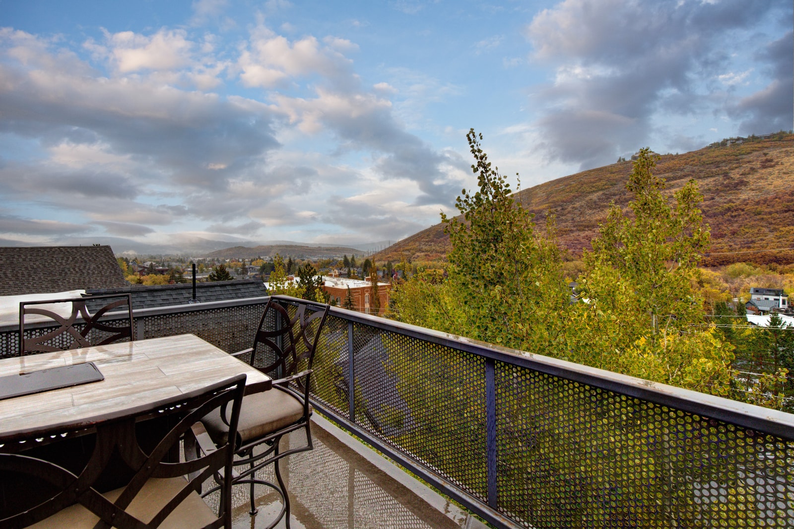 Balcony with full outdoor dining setup and sweeping valley views invites you to dine outside.
