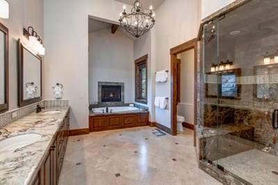 Your primary ensuite includes a soaking tub, granite vanity, and a two-sided fireplace for extra ambiance.