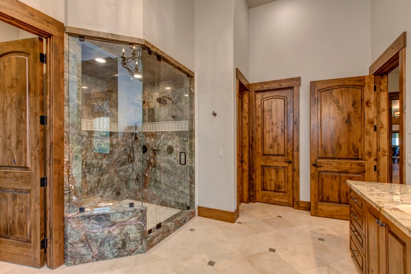 Rustic wood finishes meet modern luxury in this stylish primary bath.