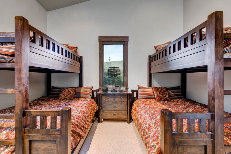 Rustic bunk beds with vibrant patterns and cozy cabin charm.