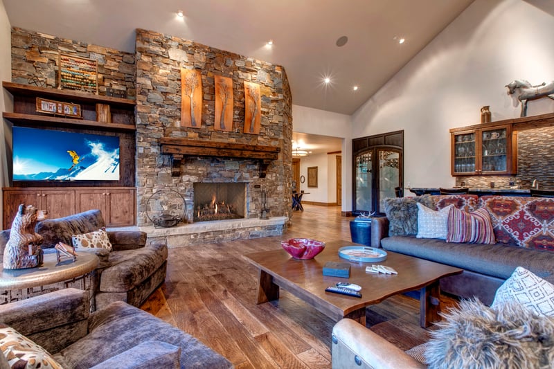 Lounge wood burning fireside while others prep snacks in the kitchen just beyond this inviting open-concept living room.