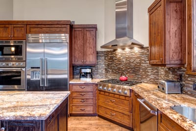 A chef’s kitchen with granite counters and gas range makes meal prep feel effortless.
