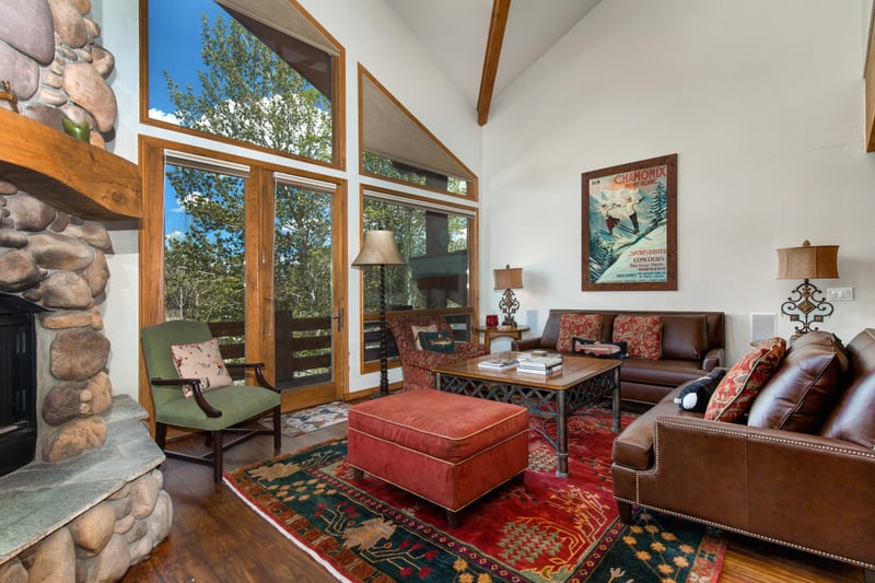 Floor-to-ceiling windows frame wooded views and flood the space with natural light and mountain charm.