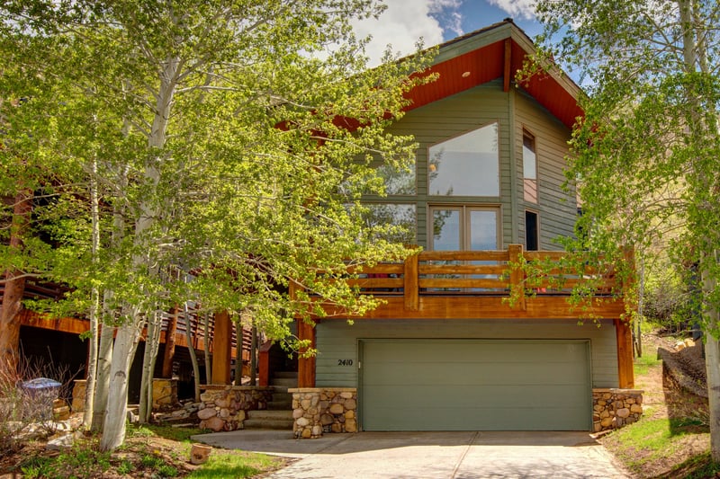 Private entrance with stone steps and mature trees offers a warm mountain welcome.