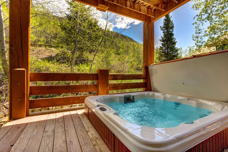 Private hot tub tucked under a pergola, ideal for soaking after a day on the slopes or trails.