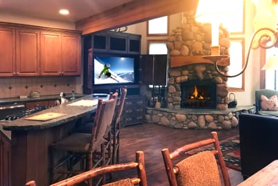 Open-concept great room with wood floors, vaulted ceilings, and oversized windows for all-day light.