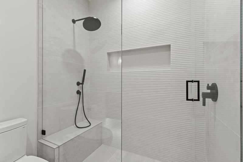 Guest bathroom, this sleek ensuite includes a walk-in shower and modern finishes.