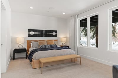 Guest suite with King bed, TV, lounge space, and mountain-facing windows.