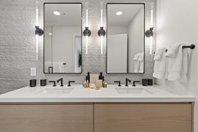 This bath features a dual vanity and textured tile walls for a luxe finish.