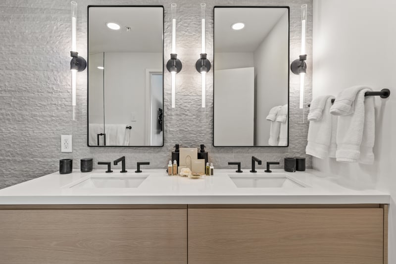 This bath features a dual vanity and textured tile walls for a luxe finish.
