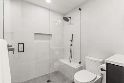 Ensuite bath with walk-in shower and tile wall, serving Bedroom 4.