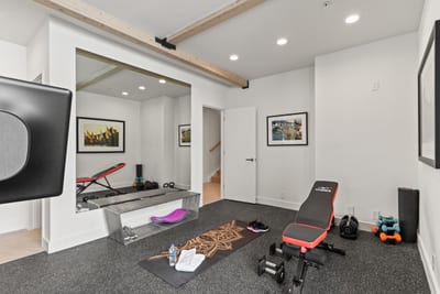 This second fitness room features a Peloton and yoga gear for total wellness.