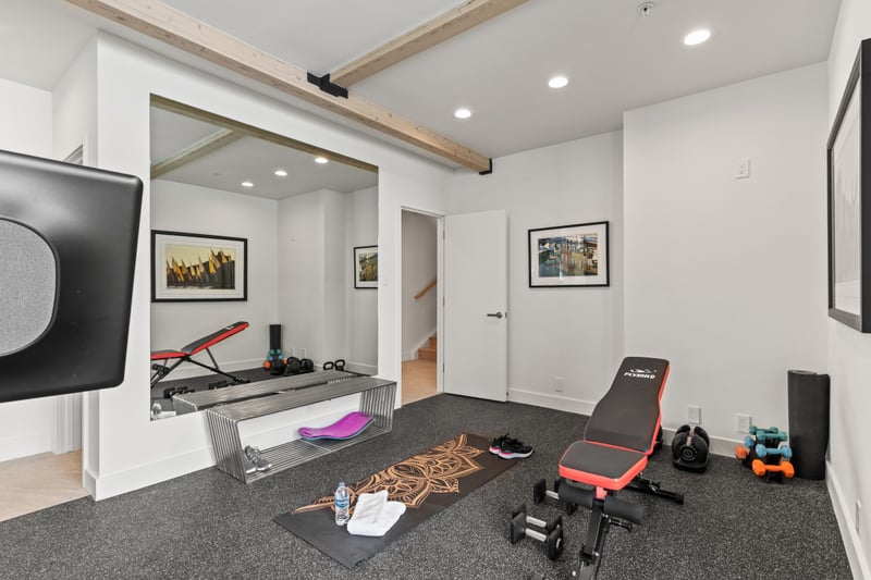 Workout room features a Peloton and yoga gear for total wellness.