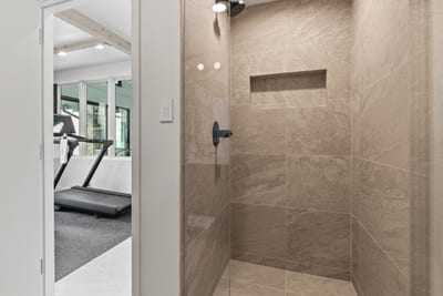 Spa-style bath with rainfall shower near the gym and pool. Ideal for post-workout refresh.