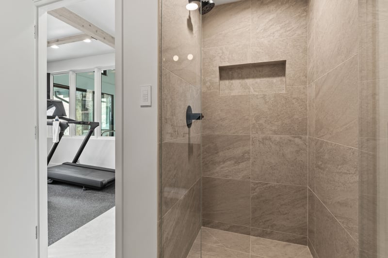 Spa-style bath with rainfall shower near the gym and pool. Ideal for post-workout refresh.