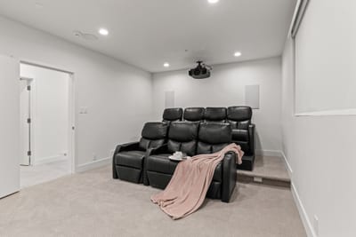 Movie lounge with tiered seating and blackout-ready walls for full immersion.