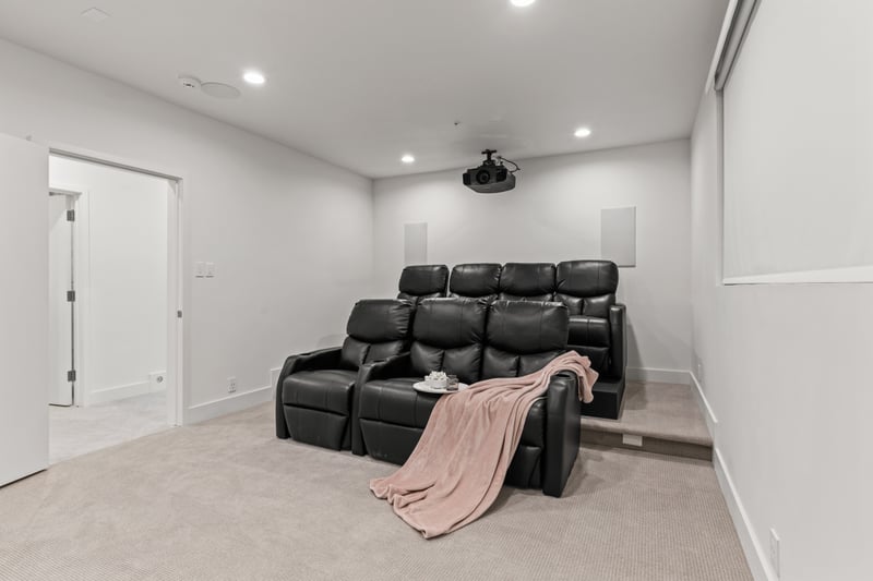 Movie lounge with tiered seating and blackout-ready walls for full immersion.