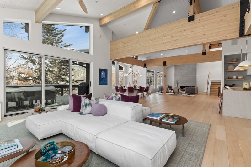 Floor-to-ceiling windows and a sleek fireplace bring warmth and light to this elevated gathering space.