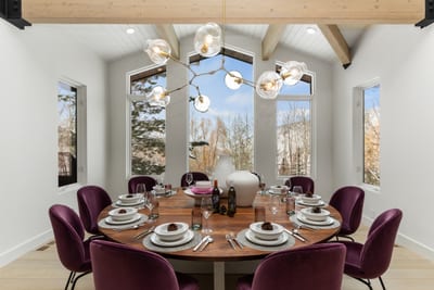 Formal dining space for ten with forest views and rich velvet seating. Ideal for celebrations.