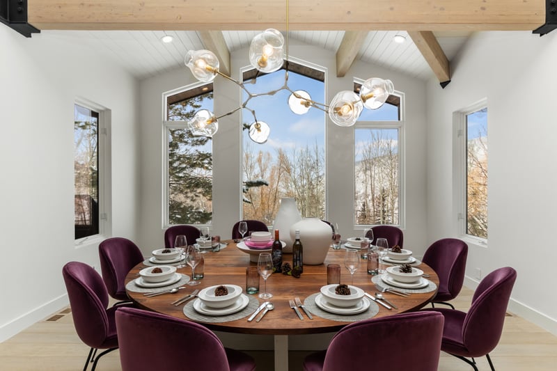 Formal dining space for ten with forest views and rich velvet seating. Ideal for celebrations.