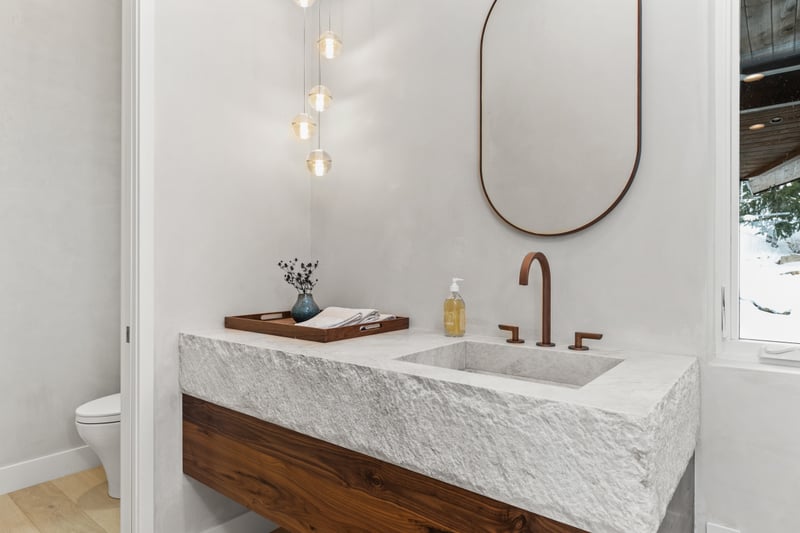 Elegant powder room with stone sink and brass accents, perfect for guests on the main level.