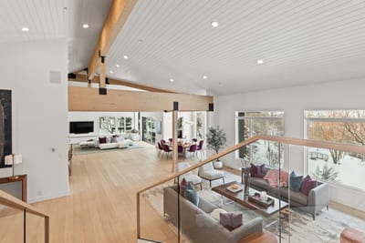 This wide-angle view shows the open flow from the main living room into kitchen and dining.