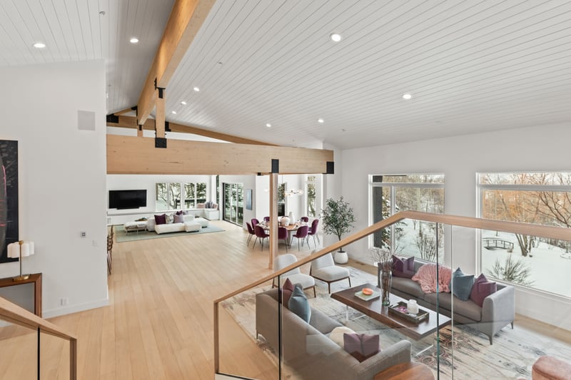 This wide-angle view shows the open flow from the main living room into kitchen and dining.