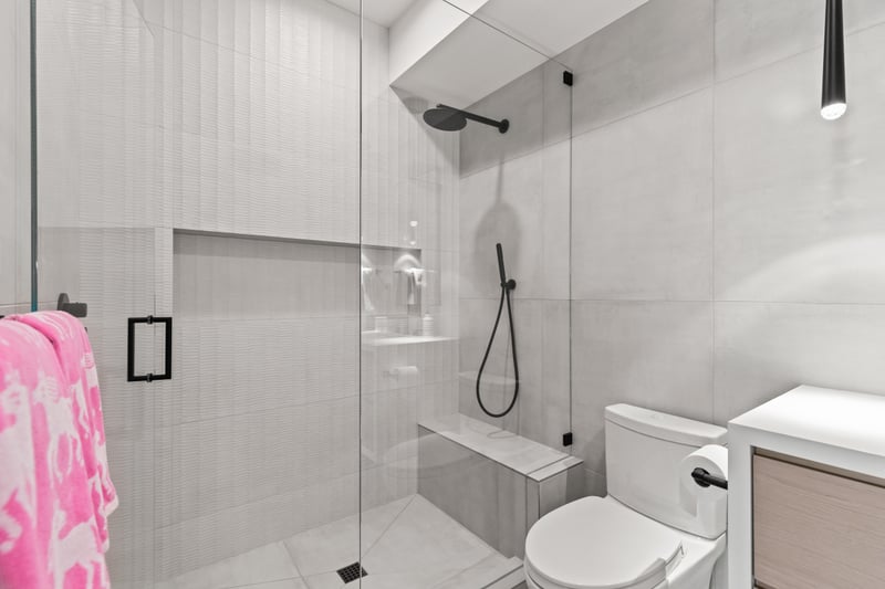 Private bath with walk-in shower and wall-mounted vanity attached to the bunk suite.