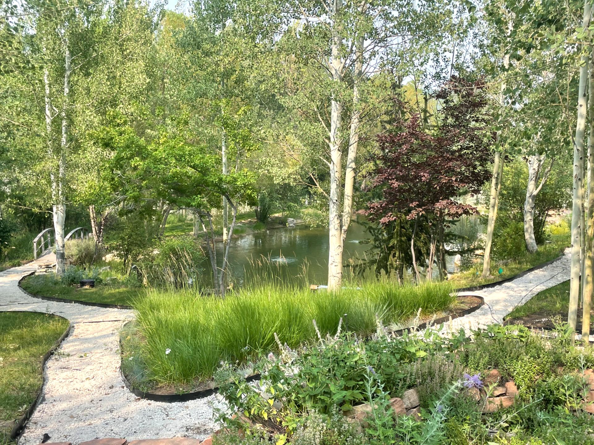 Landscaped paths wind through lush trees and peaceful water features.