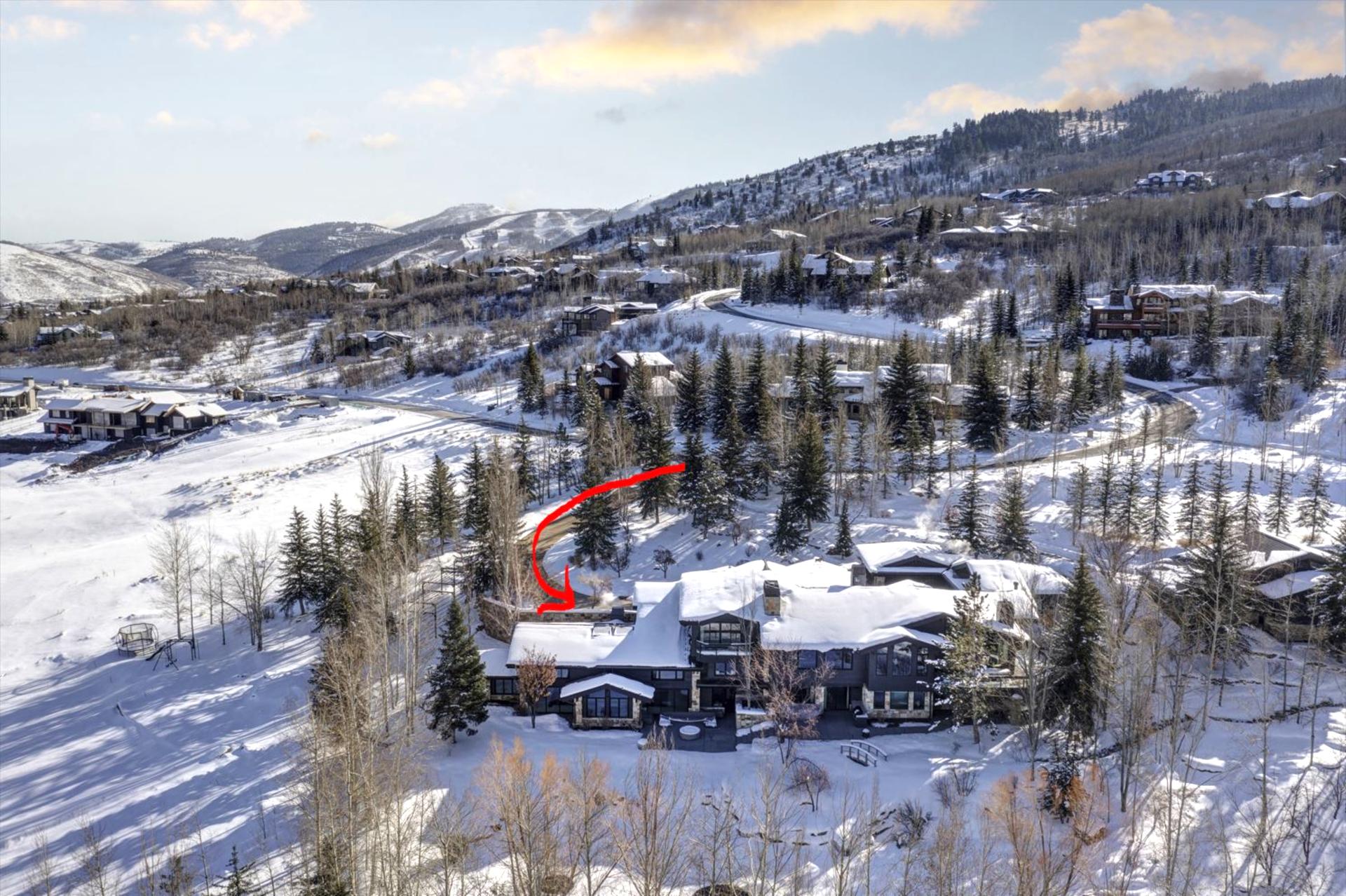 Aerial view reveals the full estate and private setting surrounded by forest and trails.