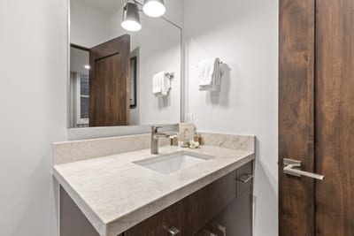 Clean and modern, this attached bath includes granite vanity and sleek design touches.