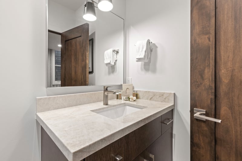 Clean and modern, this attached bath includes granite vanity and sleek design touches.