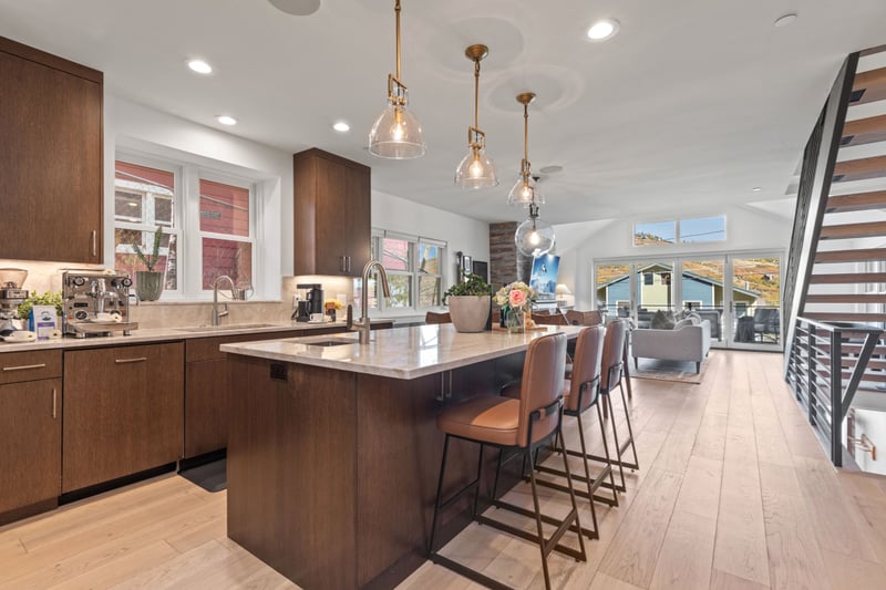 A second view shows the open-concept layout connecting kitchen, dining, and living areas across the main level. PEA-1009
