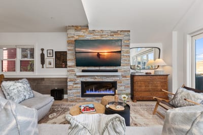 Natural light fills this cozy lounge space with modern furnishings and an inviting fireplace. PEA-1009
