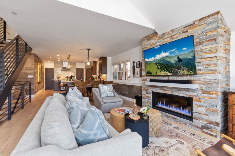 This alternate living room view shows smart TV, fireplace, and layered textures for comfort and connection. PEA-1009