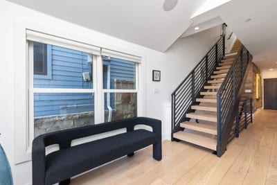 Wide stairwells and modern railings offer a clean, open flow between all three levels of the home. PEA-1009