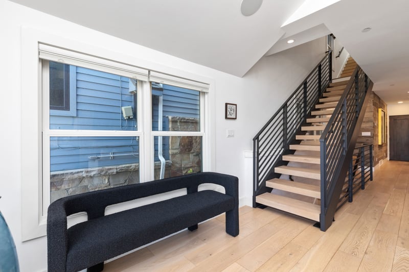 Wide stairwells and modern railings offer a clean, open flow between all three levels of the home. PEA-1009