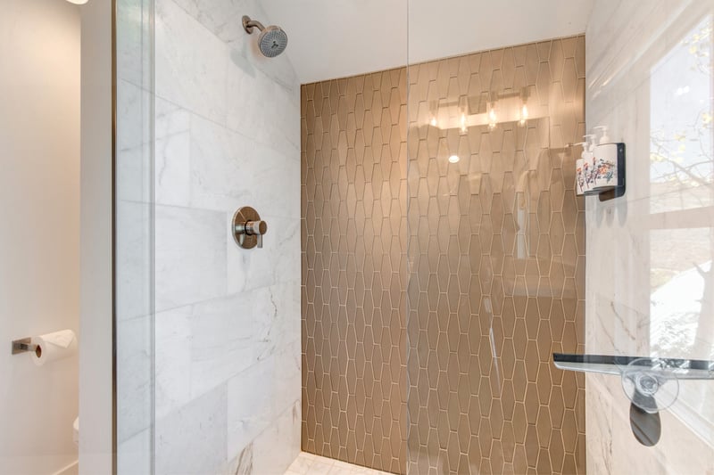 Walk-in shower with glass doors and modern tile makes this bath feel premium and fresh.