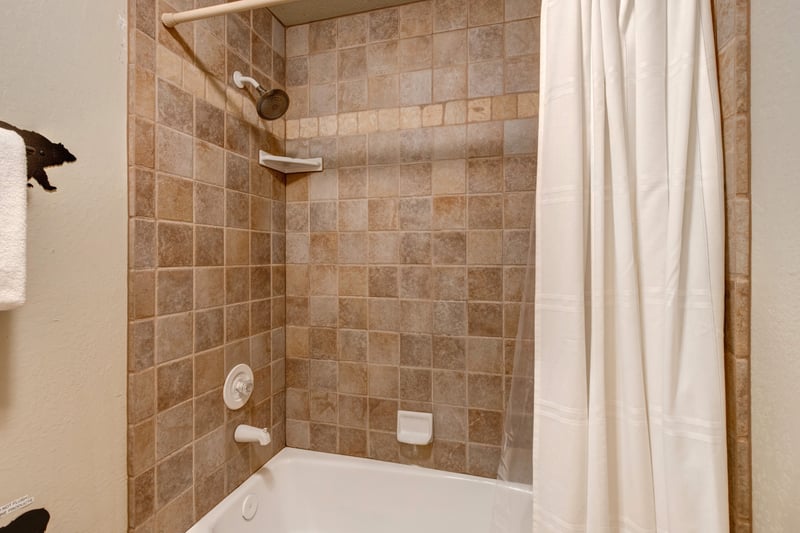 The shared hallway bath features a tub/shower combo and granite vanity