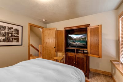Catch a movie from bed or wind down with a book in this bright and inviting guest space.