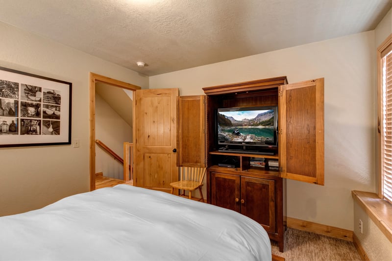 Catch a movie from bed or wind down with a book in this bright and inviting guest space.
