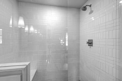 A closer look at the glass walk-in shower with tile surround, perfect for a relaxing rinse after a day out.